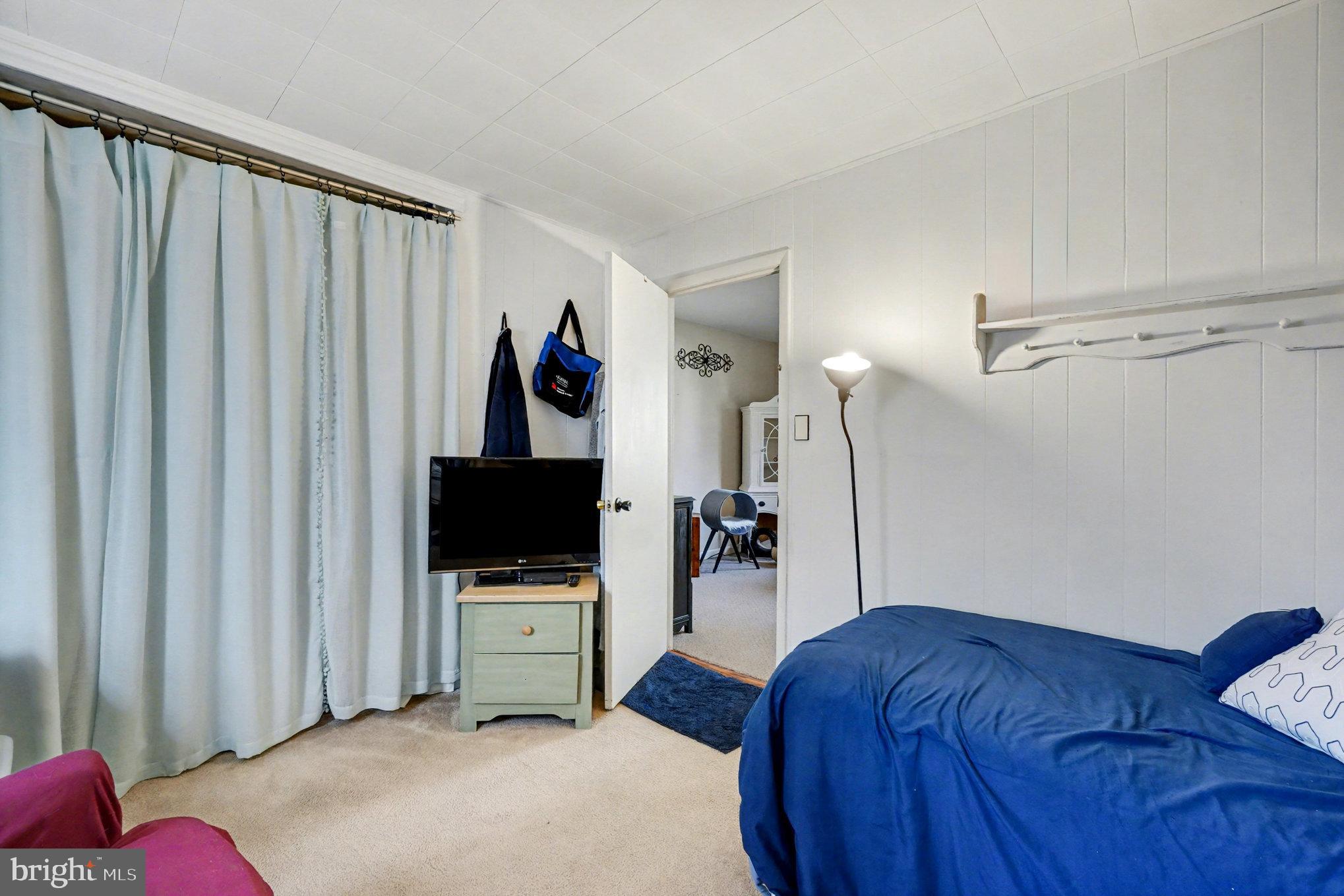 7316 Hughes Avenue Baltimore, MD 21219 - Photo 23 of 43 a bedroom with a bed and a flat screen tv