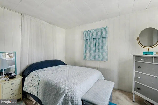 a bedroom with a bed and a flat tv screen on wall