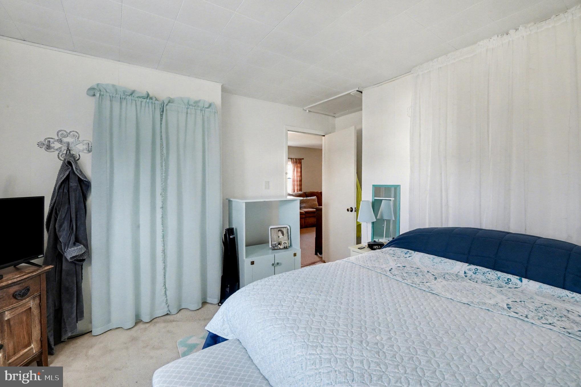 7316 Hughes Avenue Baltimore, MD 21219 - Photo 27 of 43 a bedroom with a bed and a flat tv screen on wall