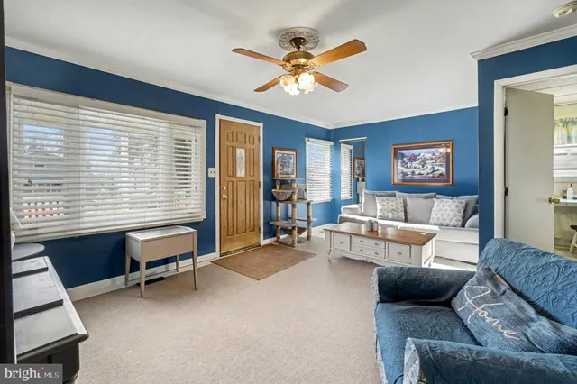 a living room with furniture and a ceiling fan