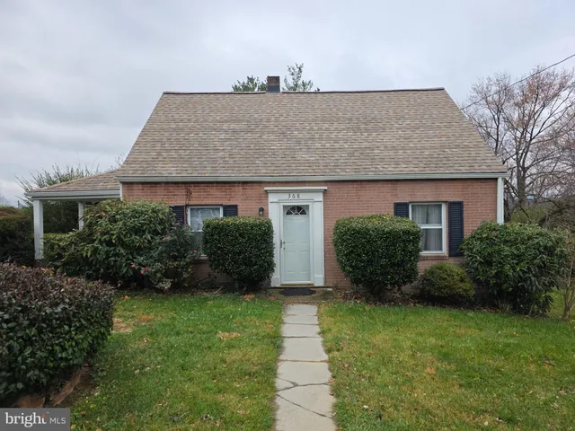 a front view of a house with a yard and potted plants