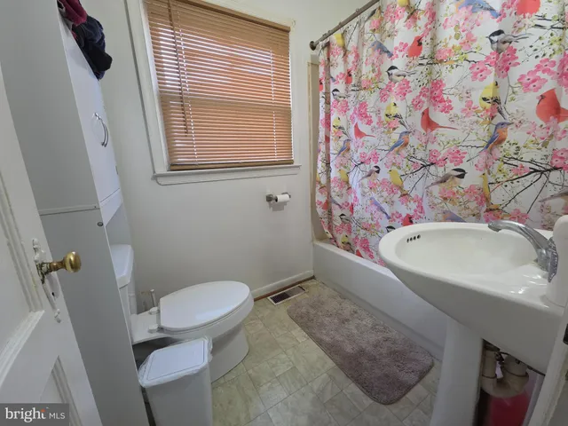 a bathroom with a sink toilet and window