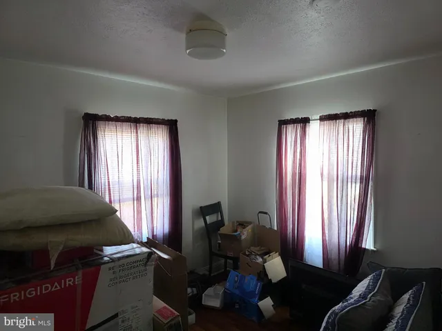 a bedroom with a bed and windows