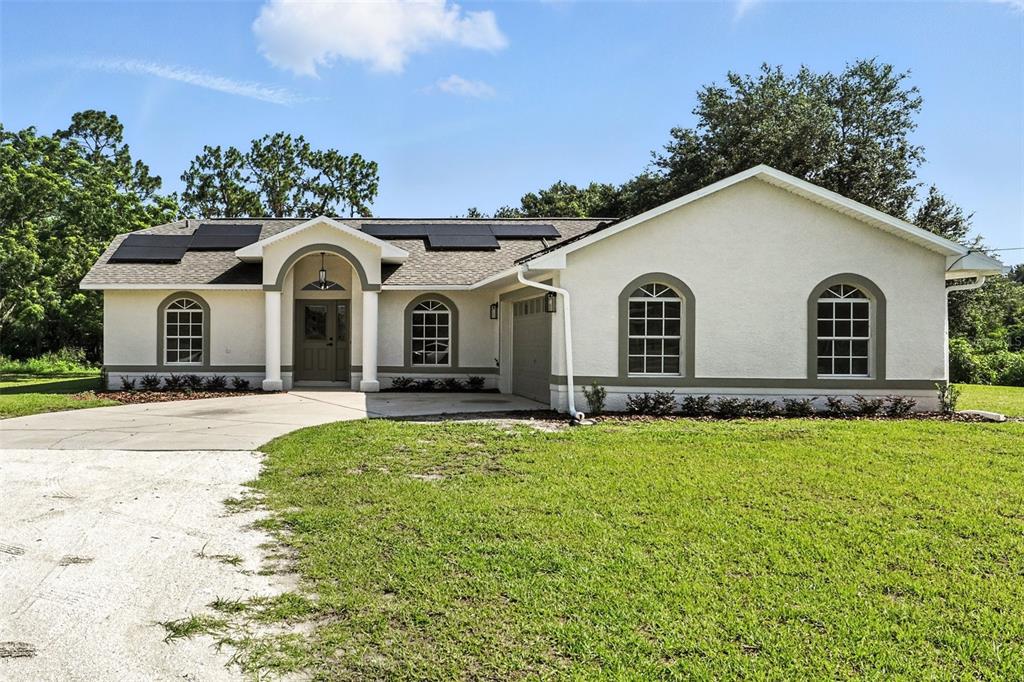 a view of a white house with a yard