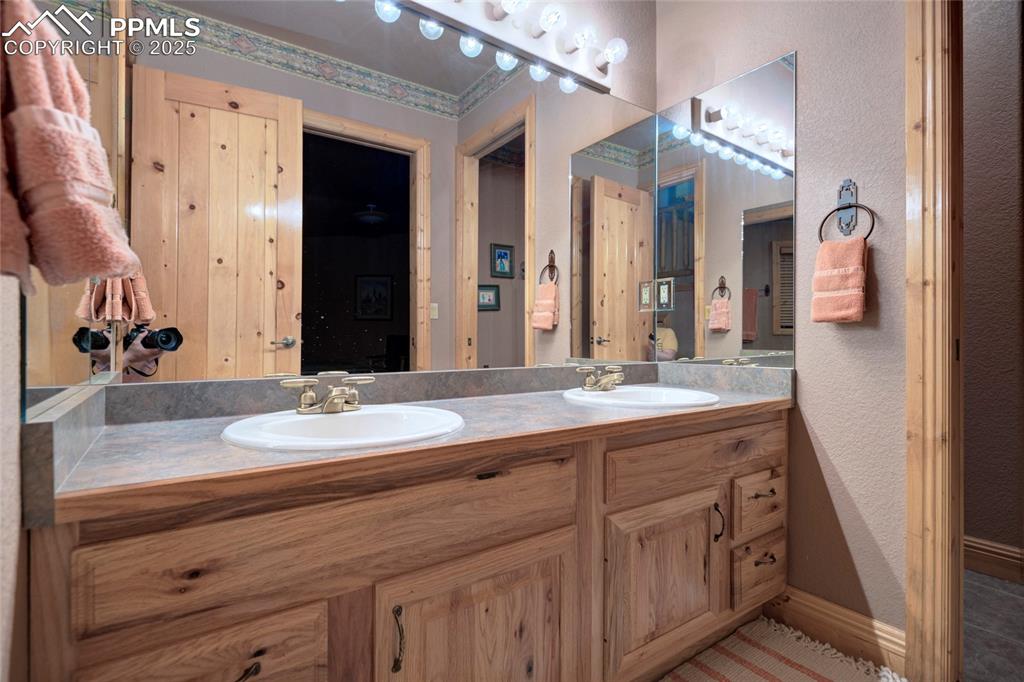 11771 East Smith Road Elbert, CO 80106 - Photo 22 of 35 a bathroom with a granite countertop double vanity sink and a mirror