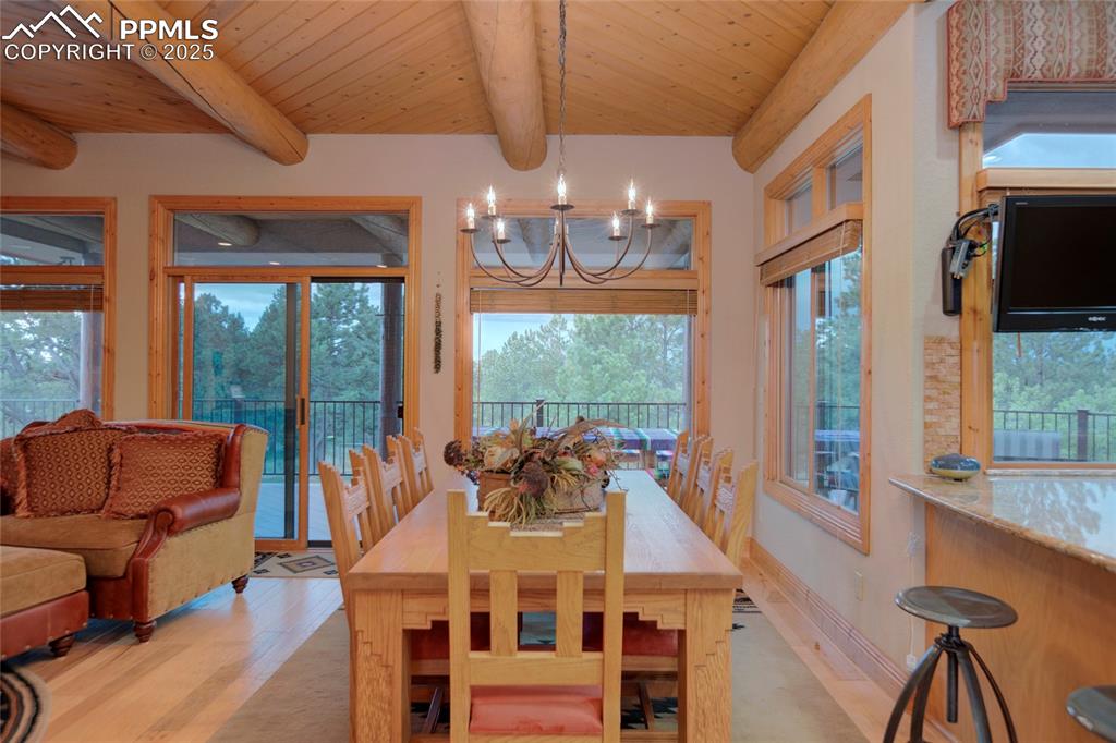 11771 East Smith Road Elbert, CO 80106 - Photo 30 of 35 a view of a dining room with furniture a chandelier and large windows