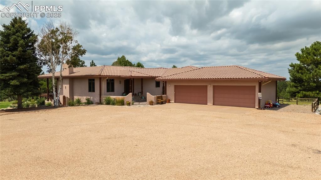 11771 East Smith Road Elbert, CO 80106 - Photo 6 of 35 a front view of a house with a garden and trees