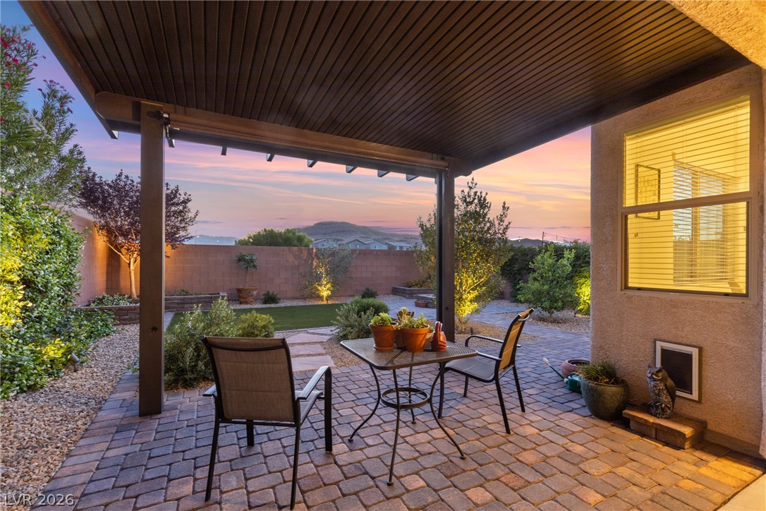 891 Earth Luster Road Las Vegas, NV 89178 - Photo 36 of 48 A private outdoor space with a paved patio and lush garden offers sunset views.