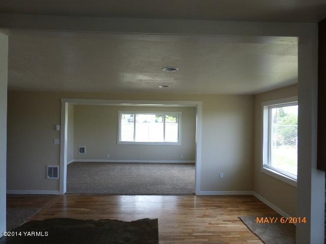 12606 Nelson Road Yakima, WA 98903 - Photo 8 of 21 an empty room with wooden floor and windows