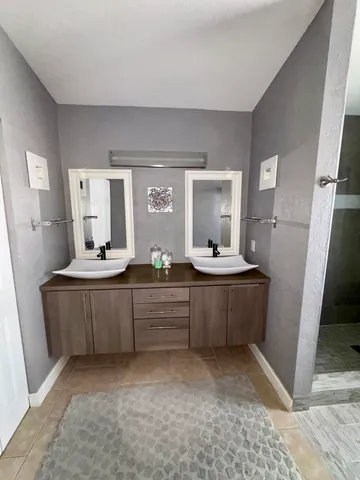 a large bathroom with a double vanity sink mirror and bathtub