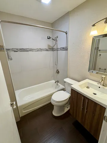 a bathroom with a sink a toilet a mirror and shower
