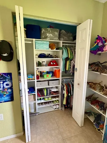 a view of walk in closet with clothes and shoes