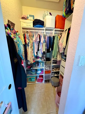 a view of walk in closet with clothes and shoes