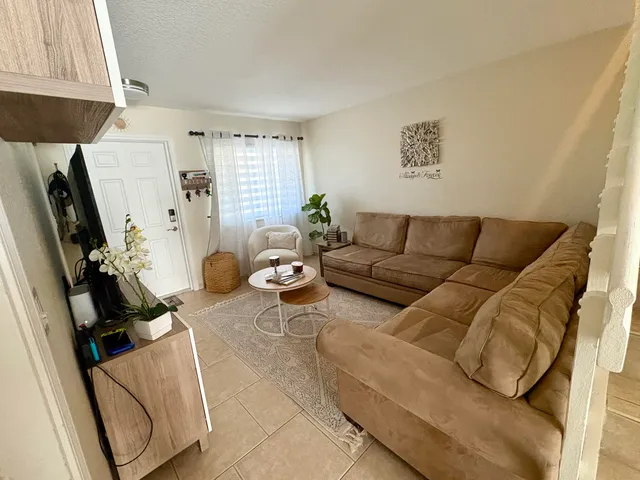 a living room with furniture a window and a flat screen tv