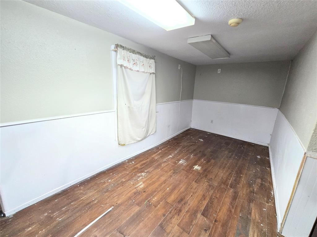 322 Capps Street Marlin, TX 76661 - Photo 18 of 34 an empty room with wooden floor and windows