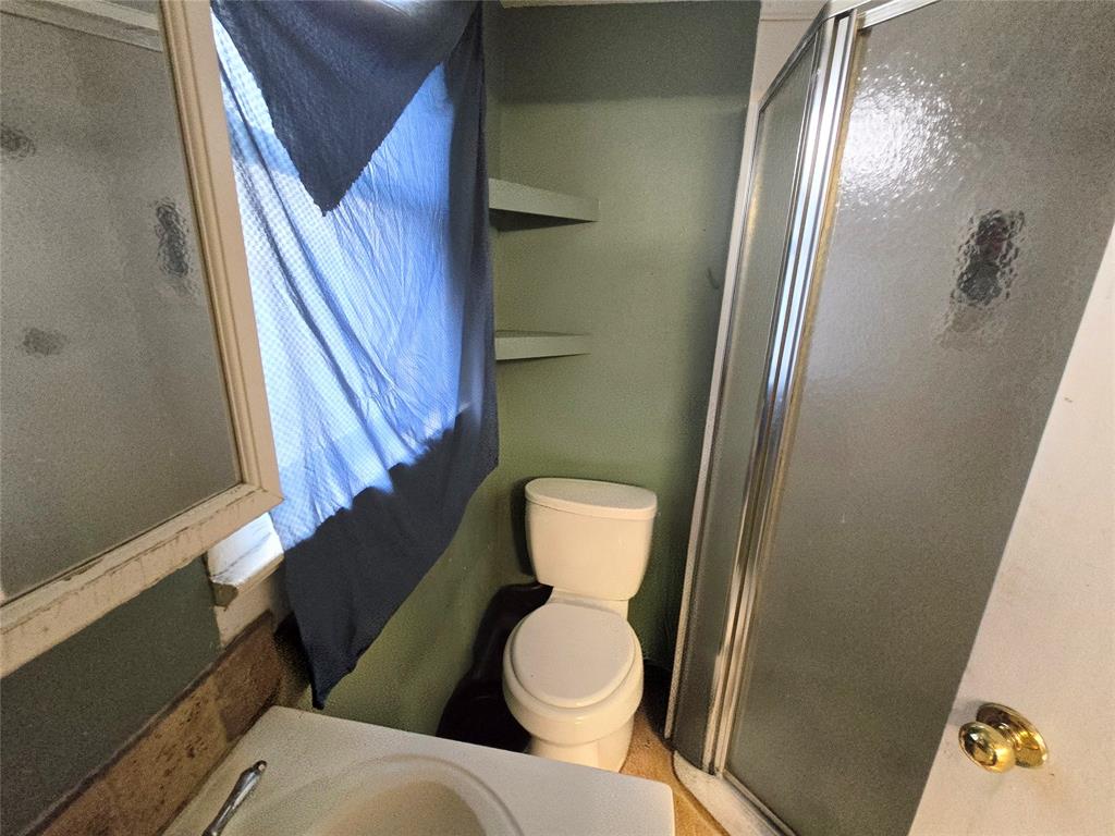 322 Capps Street Marlin, TX 76661 - Photo 28 of 34 a bathroom with a toilet and a mirror