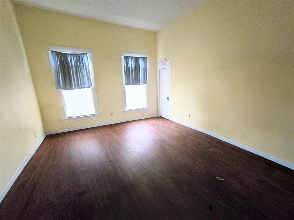 322 Capps Street Marlin, TX 76661 - Photo 10 of 34 a view of an empty room with wooden floor and windows