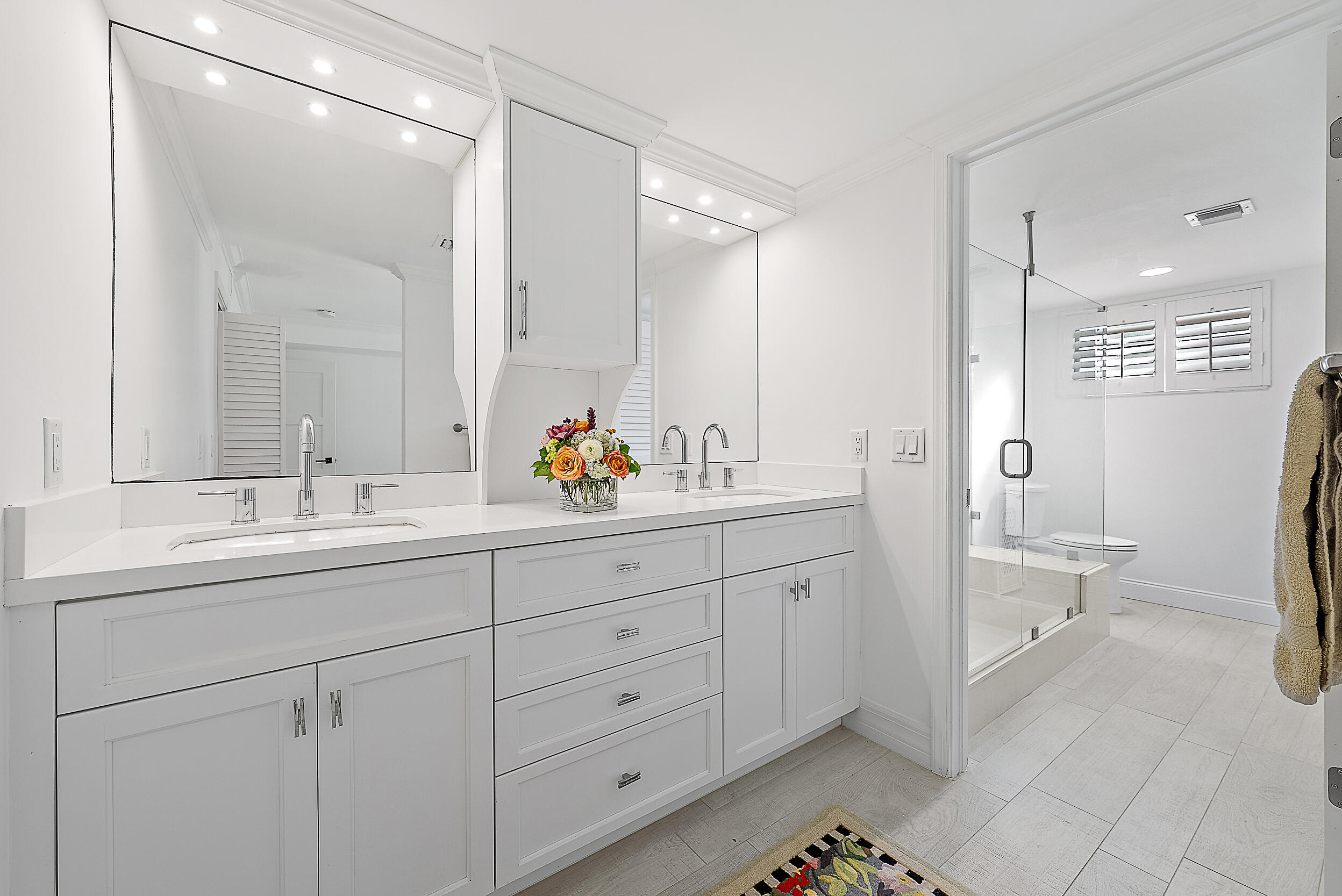 16648 Traders Crossing North, Unit 106 Jupiter, FL 33477 - Photo 14 of 37 a spacious bathroom with a double vanity sink mirror and toilet