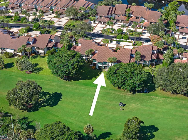 an aerial view of residential houses with outdoor space and trees