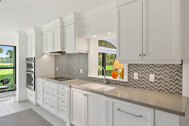a kitchen with granite countertop white cabinets and white appliances