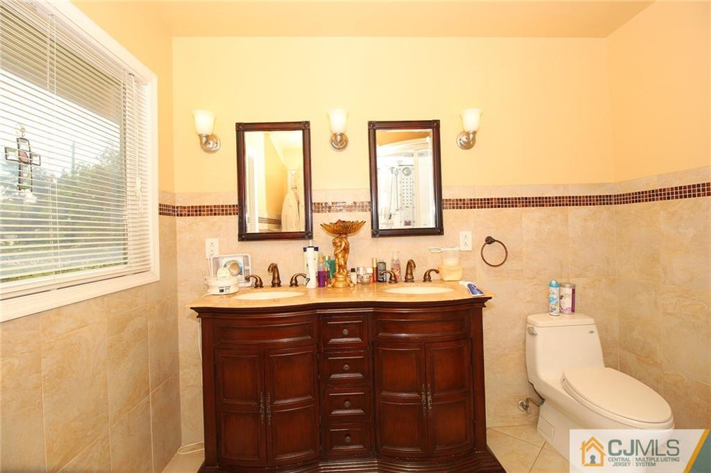21 Frances Road Edison, NJ 08820 - Photo 17 of 20 a bathroom with a toilet a sink a mirror a window and vanity