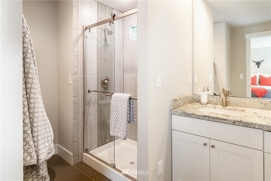 22421 53rd Avenue Southeast Bothell, WA 98021 - Photo 18 of 31 a bathroom with a granite countertop sink a mirror and shower