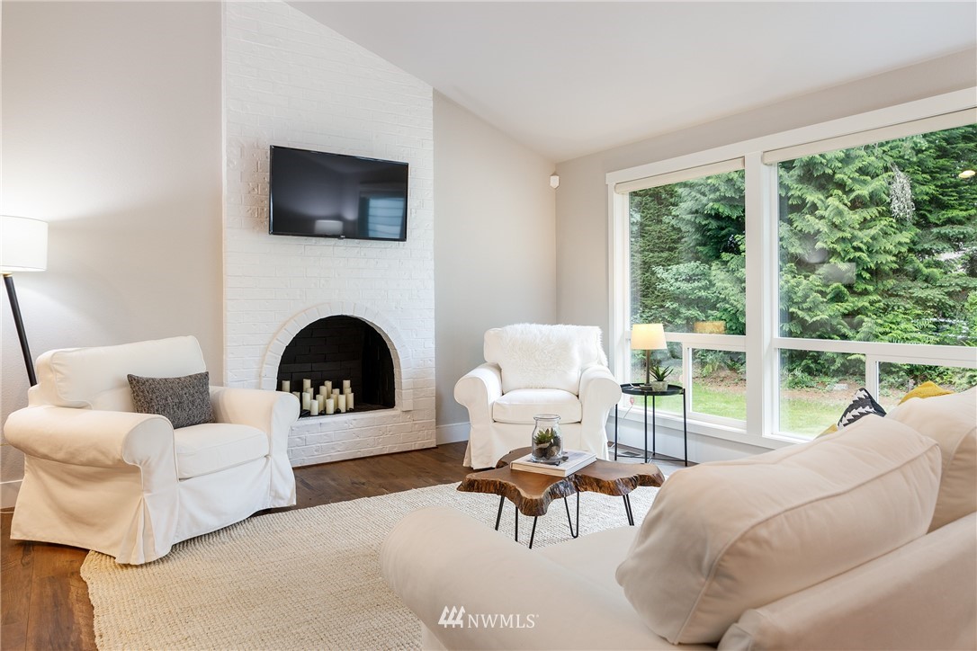 22421 53rd Avenue Southeast Bothell, WA 98021 - Photo 5 of 31 a living room with furniture a fireplace and a floor to ceiling window