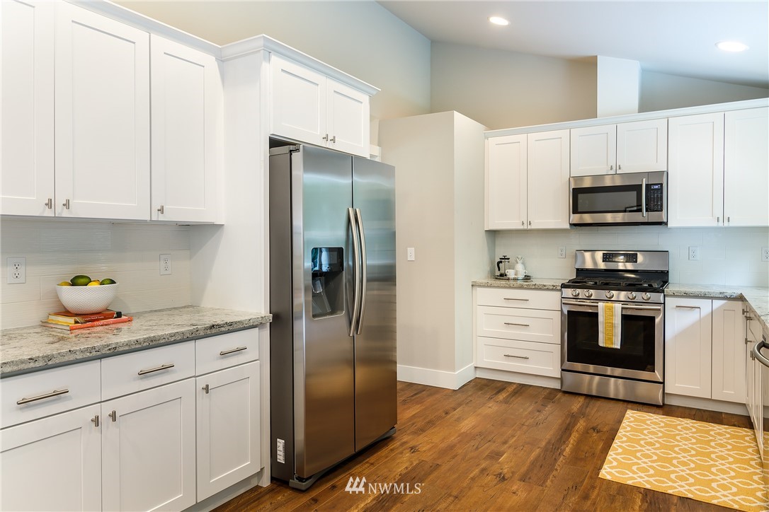 22421 53rd Avenue Southeast Bothell, WA 98021 - Photo 10 of 31 a kitchen with stainless steel appliances granite countertop a refrigerator sink and stove