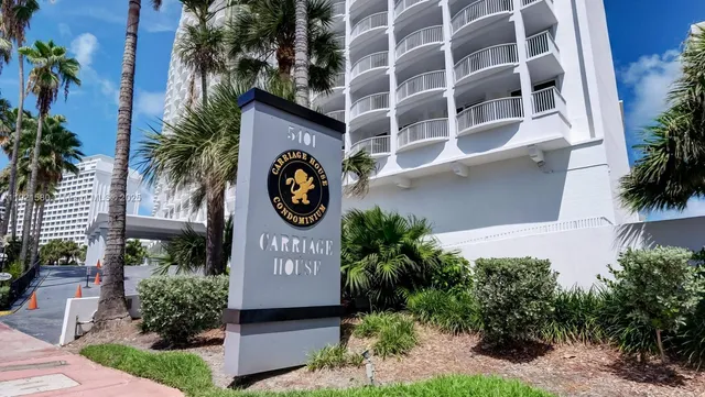 a front view of a building with garden and plants