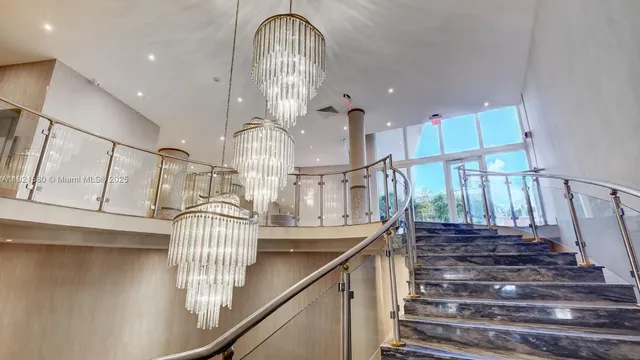 a living room with furniture a chandelier and a large window
