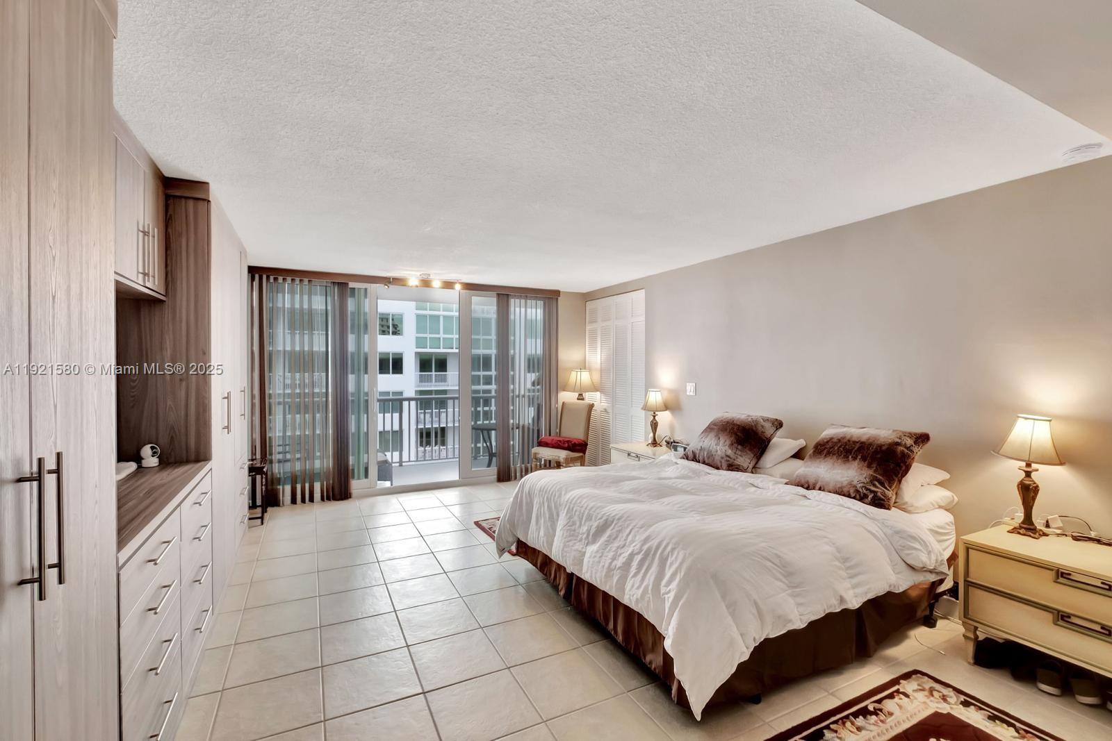 5401 Collins Avenue, Unit 340 Miami Beach, FL 33140 - Photo 38 of 54 a spacious bedroom with a bed and glass door