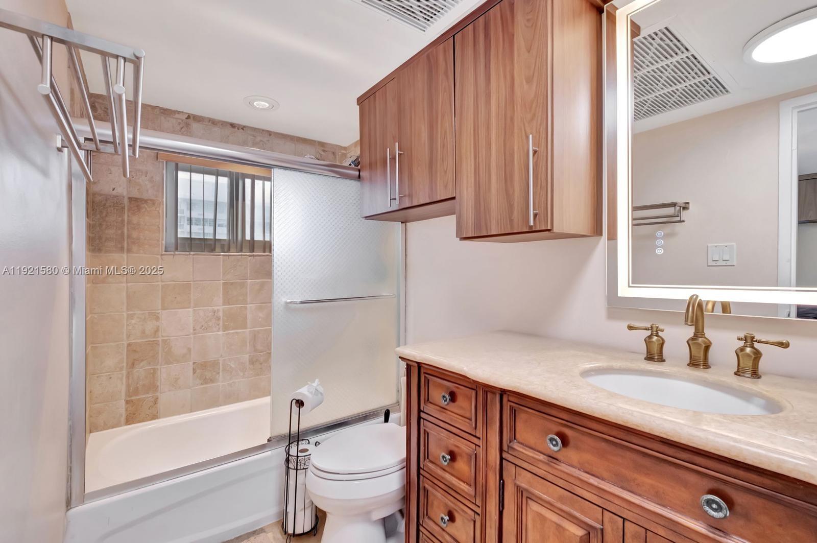 5401 Collins Avenue, Unit 340 Miami Beach, FL 33140 - Photo 39 of 54 a bathroom with a granite countertop sink toilet and shower