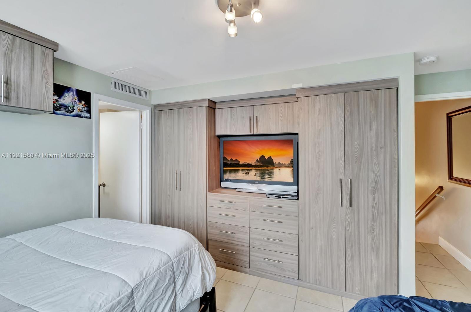 5401 Collins Avenue, Unit 340 Miami Beach, FL 33140 - Photo 41 of 54 a bedroom with a bed and a flat screen tv