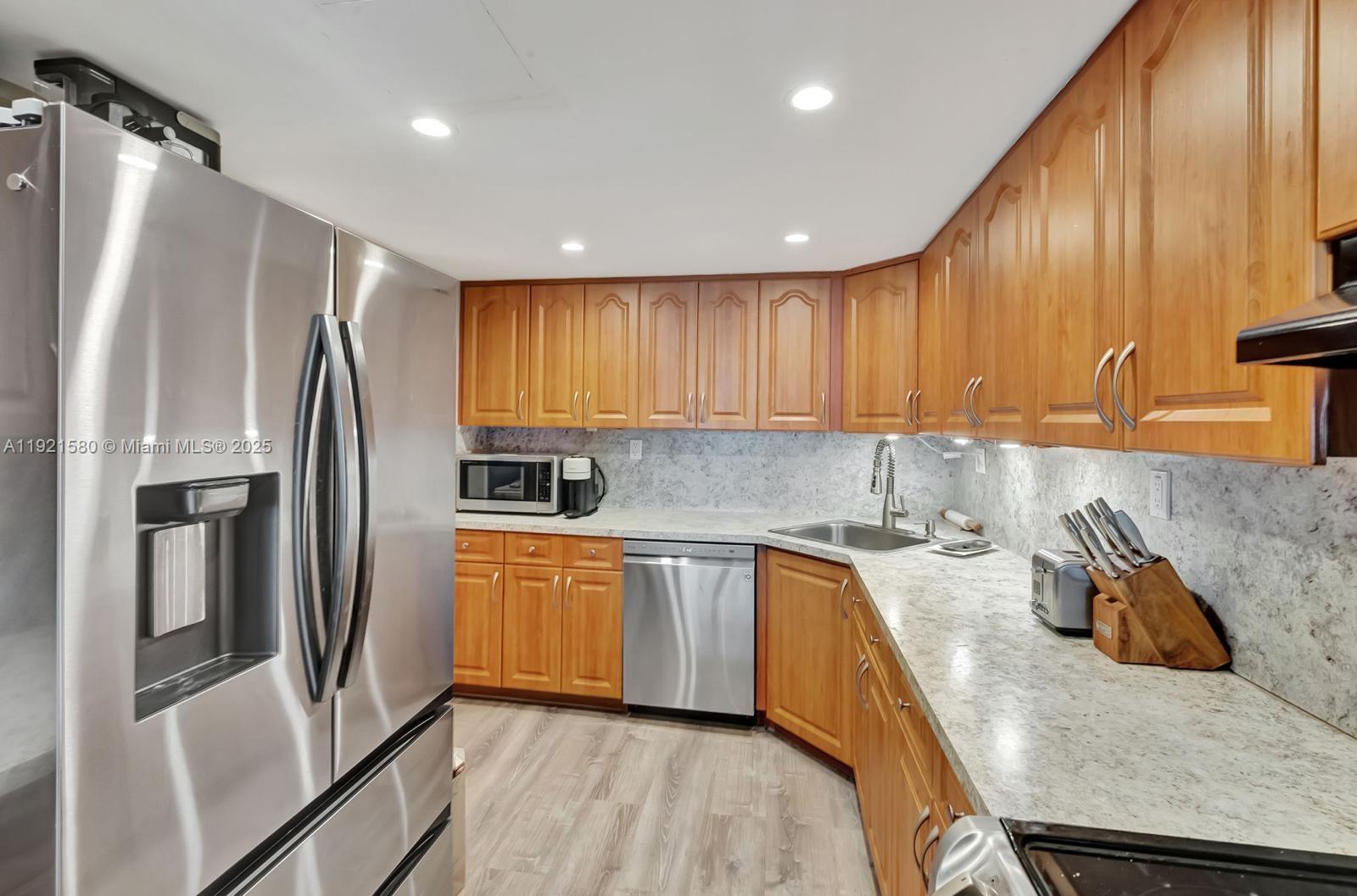 5401 Collins Avenue, Unit 340 Miami Beach, FL 33140 - Photo 43 of 54 a kitchen with stainless steel appliances granite countertop a refrigerator a sink a stove and island