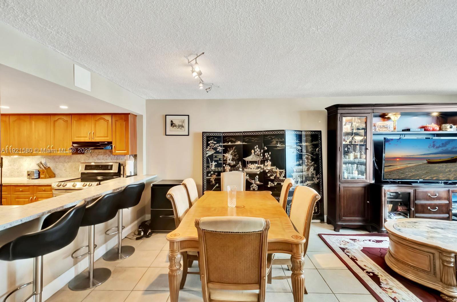 5401 Collins Avenue, Unit 340 Miami Beach, FL 33140 - Photo 53 of 54 a view of a dining room with furniture a kitchen and chandelier