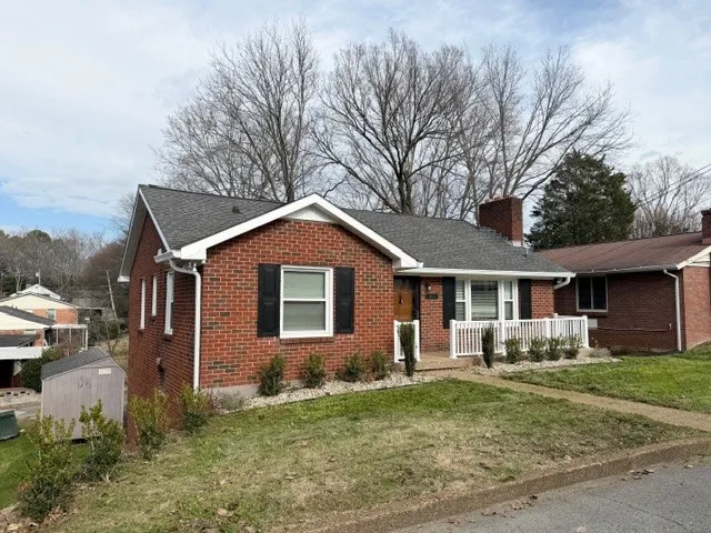 a front view of house with yard and trees all around