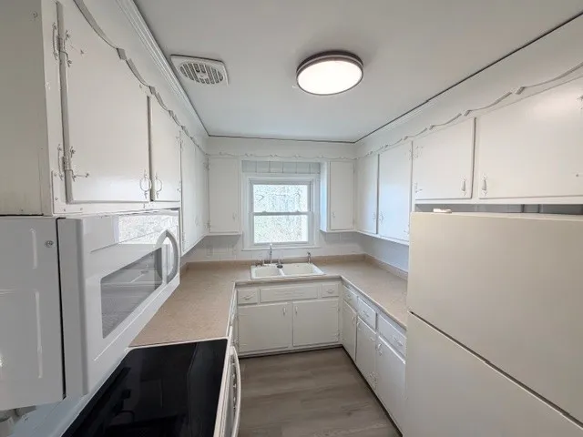 a kitchen with white cabinets and white appliances