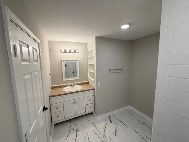 a bathroom with a granite countertop sink mirror and vanity