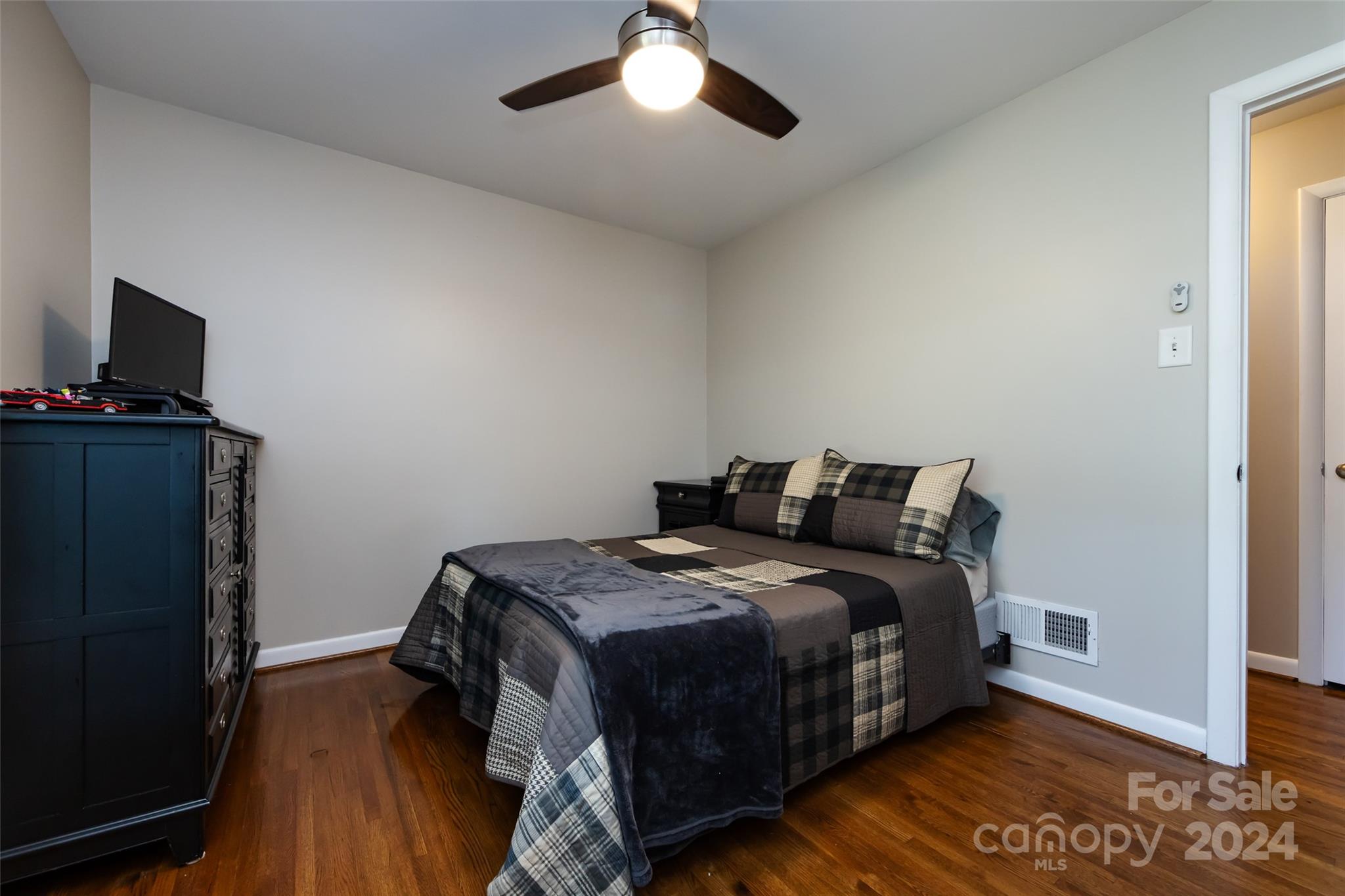 439 Boyce Road Charlotte, NC 28211 - Photo 22 of 47 a bedroom with a bed and a flat tv screen on a dresser