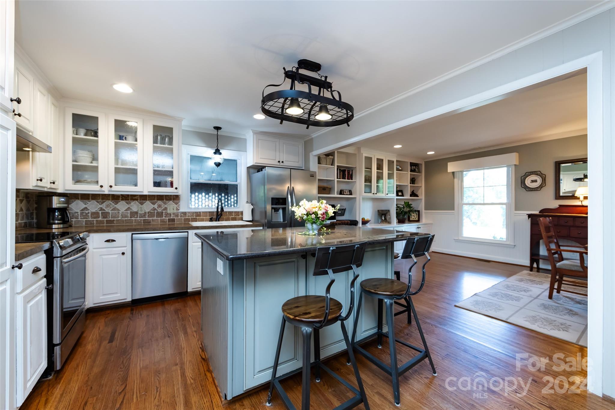 439 Boyce Road Charlotte, NC 28211 - Photo 9 of 47 a kitchen with stainless steel appliances granite countertop a stove top oven a sink dishwasher a dining table and chairs with wooden floor