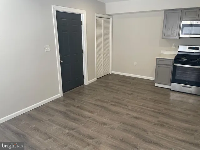 a view of a kitchen with wooden floor and electronic appliances