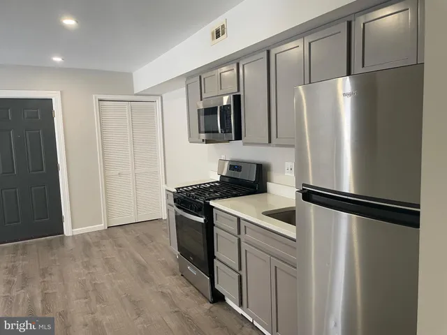 a kitchen with stainless steel appliances granite countertop a refrigerator and a stove top oven