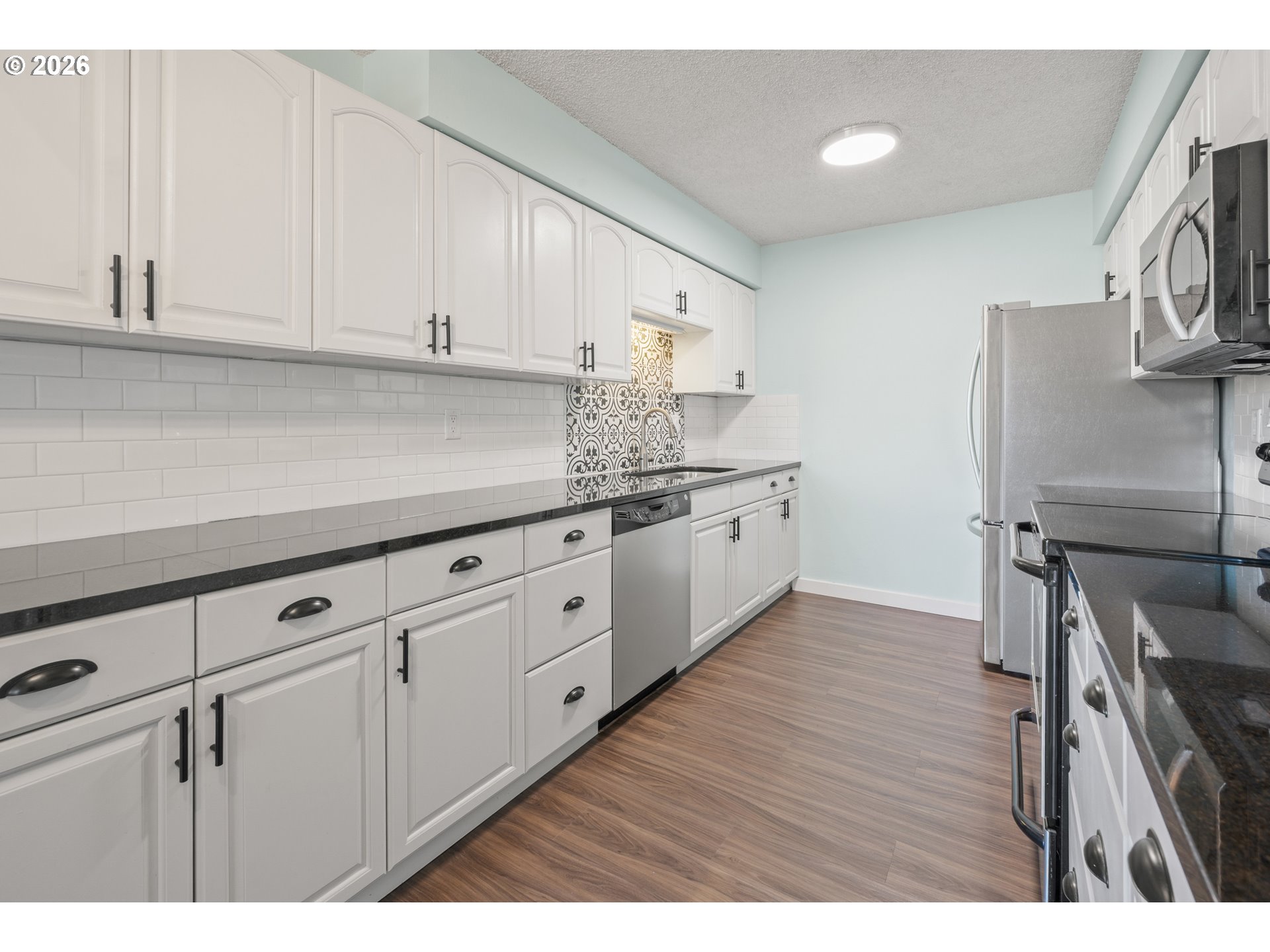 2727 Gateway Street, Unit 18 Springfield, OR 97477 - Photo 11 of 34 a kitchen with cabinets wooden floor and stainless steel appliances