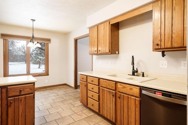 10077 Jesters Row Roscoe, IL 61073 - Photo 17 of 61 a kitchen with stainless steel appliances granite countertop a sink a stove and a wooden cabinets