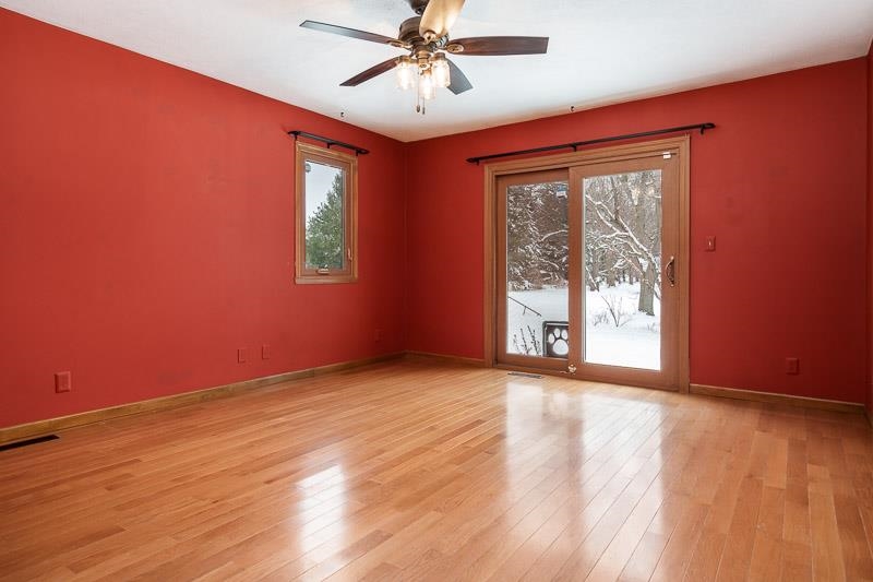10077 Jesters Row Roscoe, IL 61073 - Photo 21 of 61 a view of an empty room with a window and wooden floor