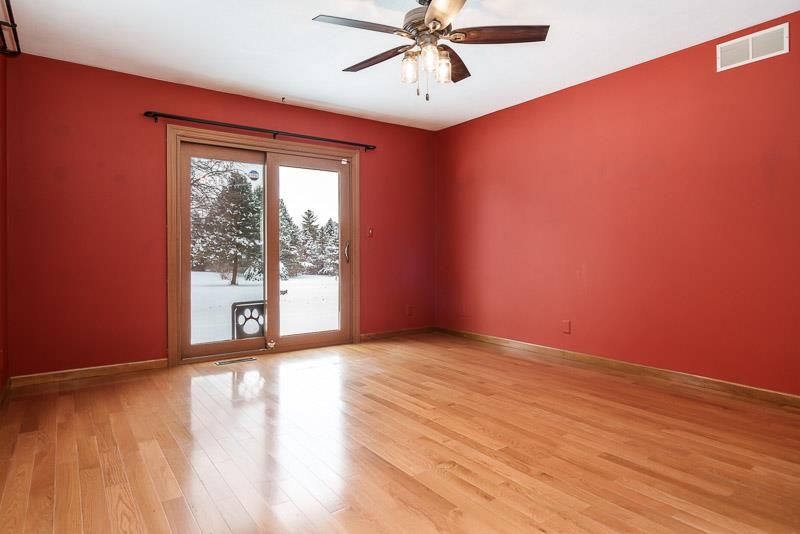 10077 Jesters Row Roscoe, IL 61073 - Photo 22 of 61 a view of an empty room with a window and wooden floor