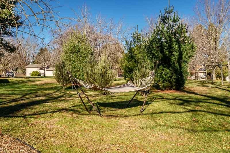10077 Jesters Row Roscoe, IL 61073 - Photo 50 of 61 a view of a swimming pool with a bench and trees in the background