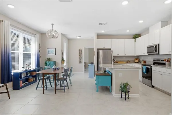 a kitchen with granite countertop white cabinets stainless steel appliances and a counter space