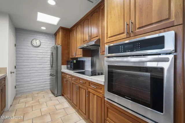 a large kitchen with stainless steel appliances granite countertop a stove and a sink