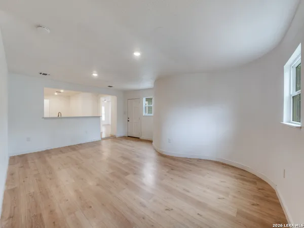 a view of empty room with wooden floor